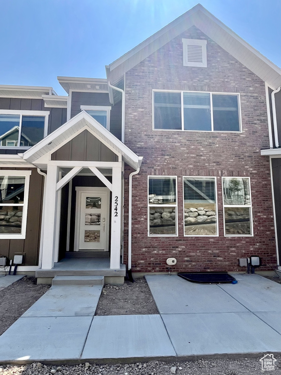 View of front of home featuring board and batten siding and brick siding