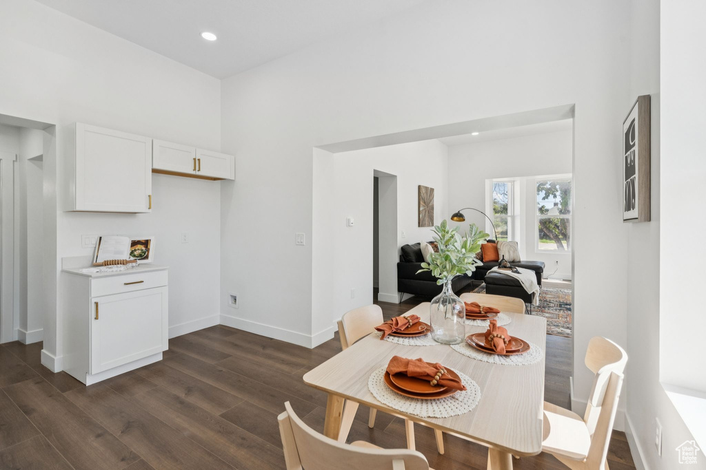 Dining area featuring dark wood-style floors, baseboards, and recessed lighting