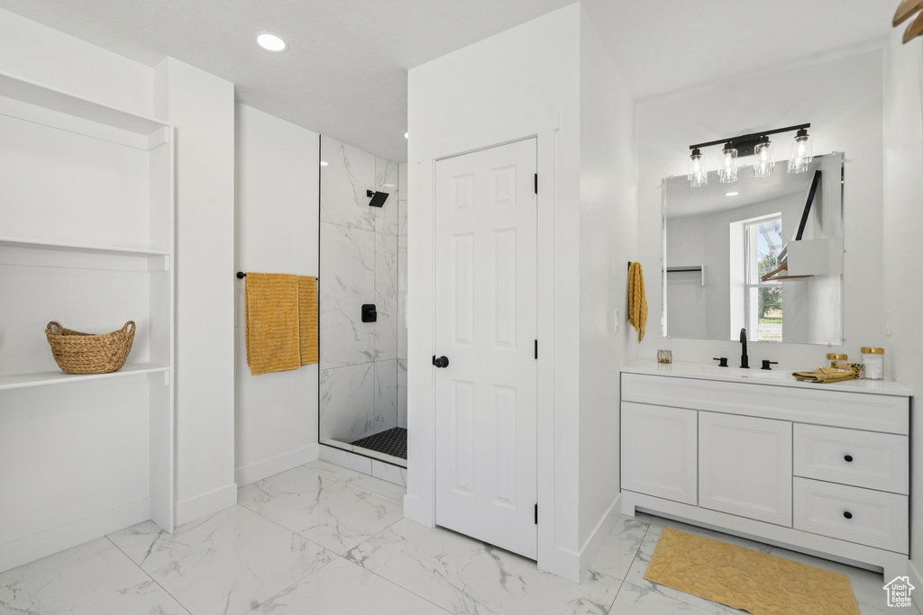Full bath with marble look tile flooring, a marble finish shower, baseboards, vanity, and recessed lighting