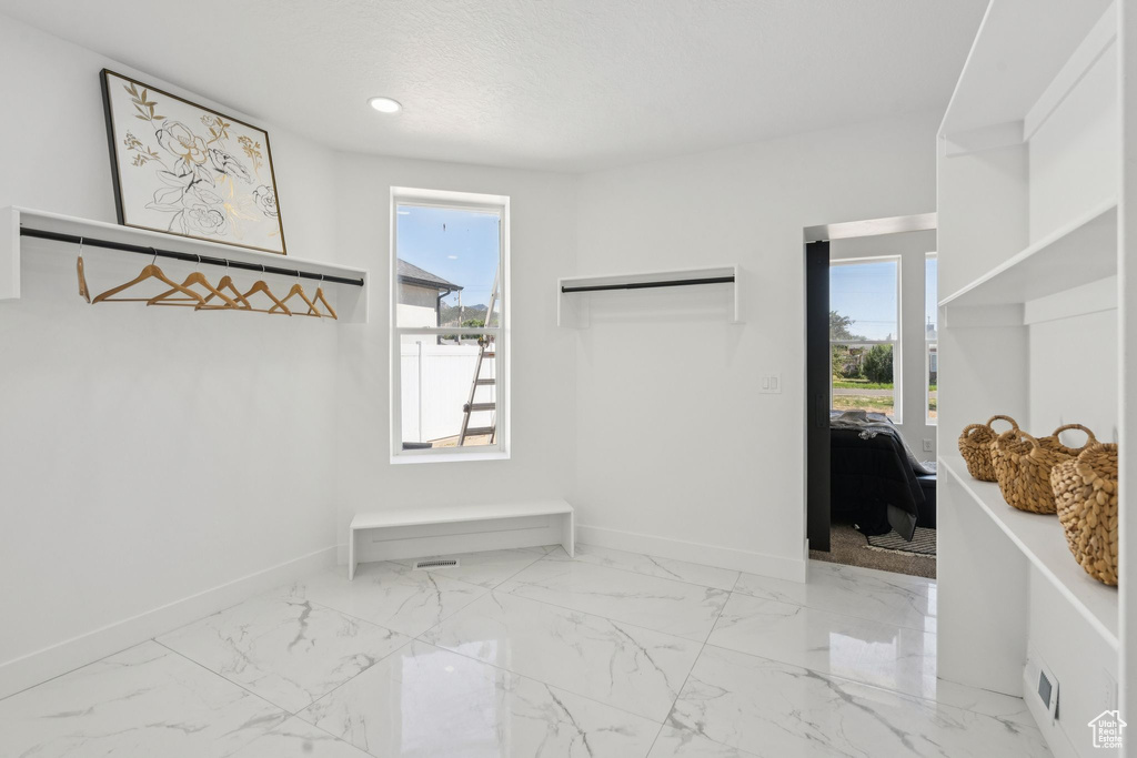 Walk in closet featuring marble look tile flooring