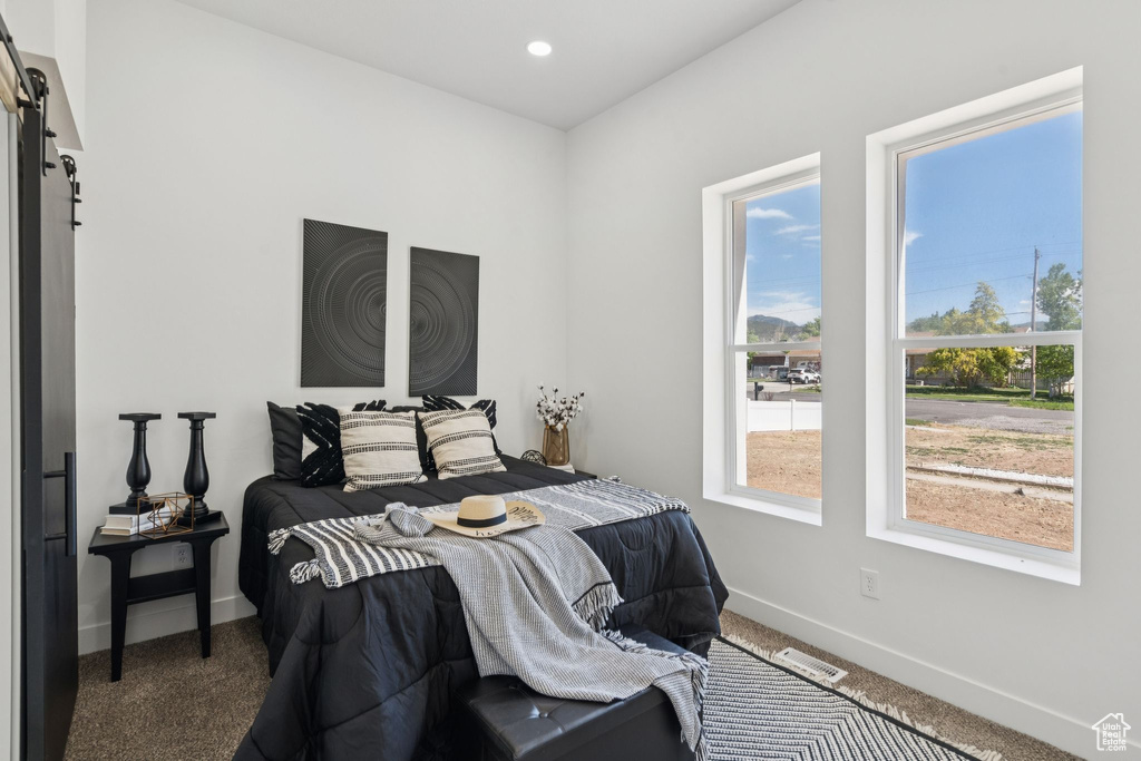Carpeted bedroom with a barn door, baseboards, and recessed lighting