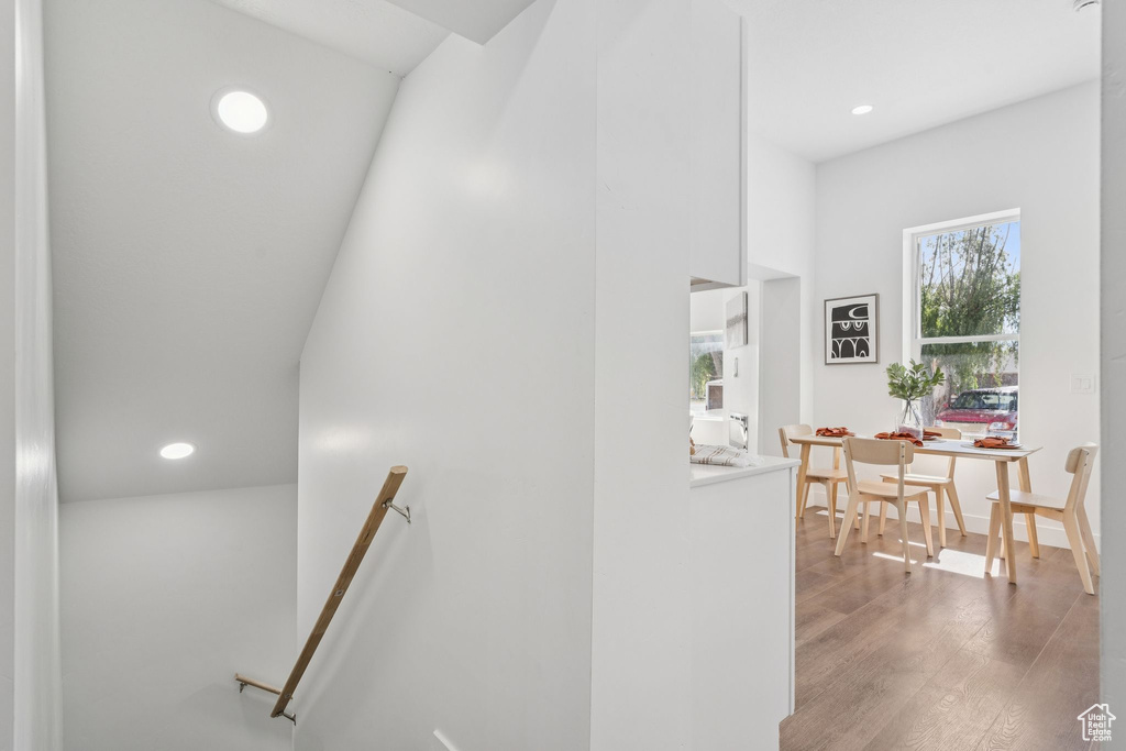 Stairs with wood finished floors and recessed lighting