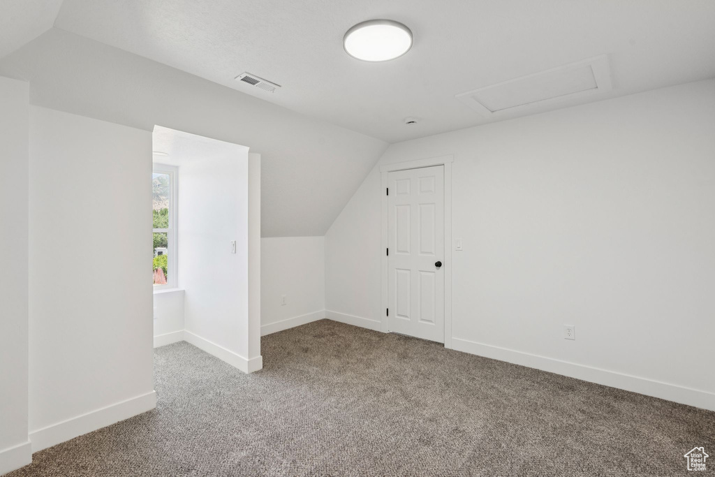 Bonus room with carpet, lofted ceiling, and baseboards