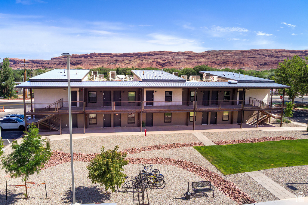 Back of property featuring stairs, a mountain view, and a metal roof