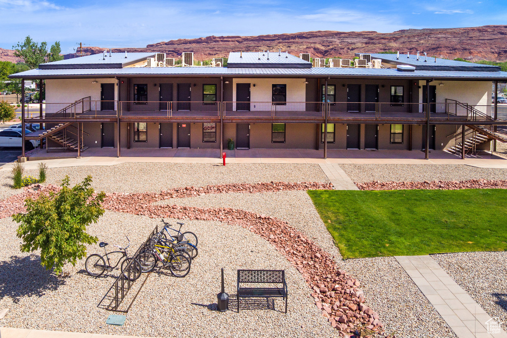 Rear view of property with stairs, a mountain view, stucco siding, and a patio area