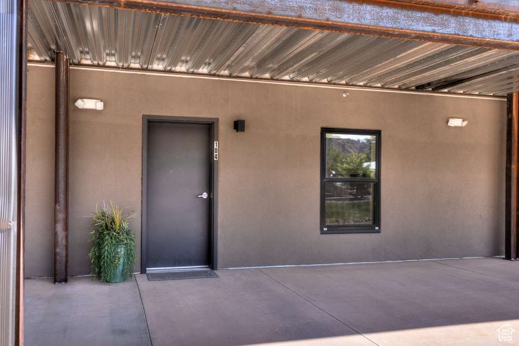 Doorway to property with stucco siding and a patio area