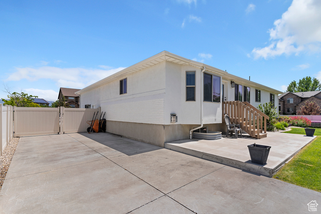 Back of property featuring a patio area, a gate, and stucco siding
