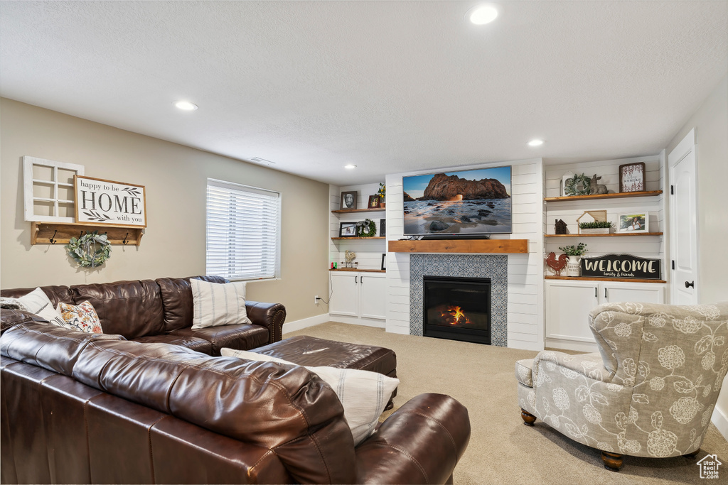 Carpeted living room with a tile fireplace and recessed lighting