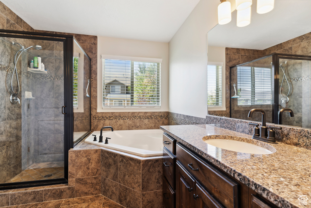 Full bath featuring vanity, a garden tub, and a stall shower