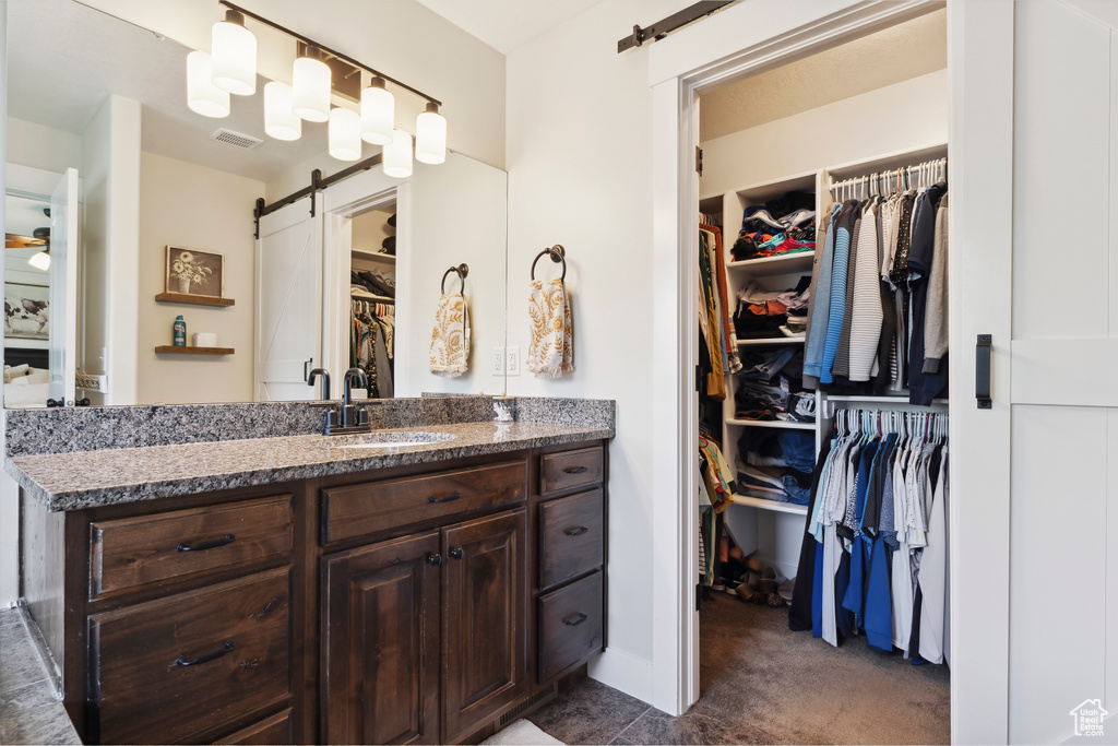 Bathroom with vanity and a spacious closet