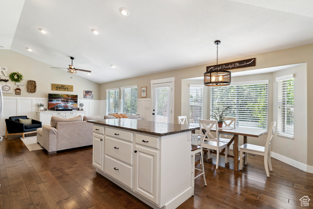 Kitchen with dark wood-style floors, a center island, white cabinetry, a ceiling fan, and lofted ceiling