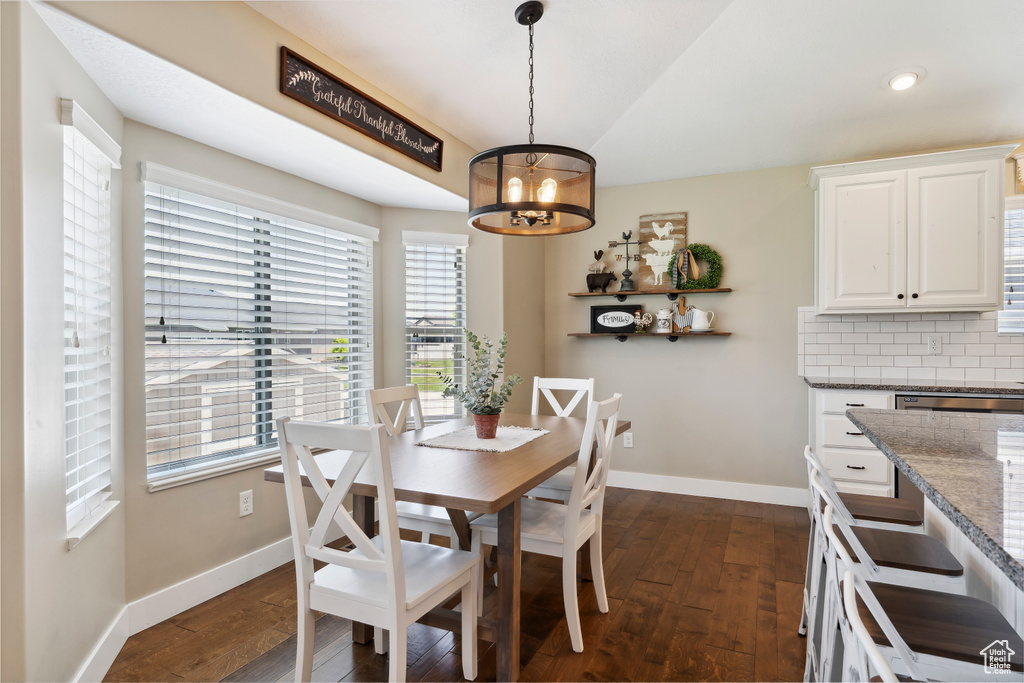 Dining room featuring dark wood finished floors, a chandelier, healthy amount of natural light, and recessed lighting