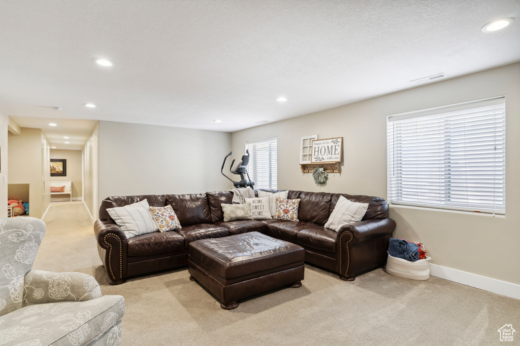 Living room with light colored carpet and recessed lighting