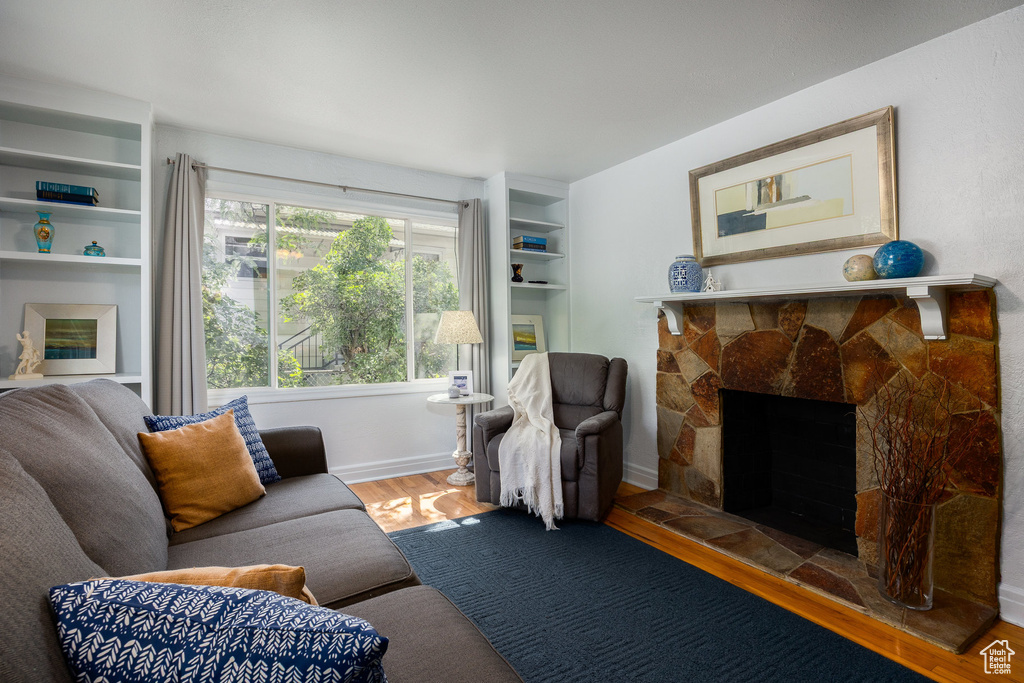 Living room featuring wood finished floors and a stone fireplace