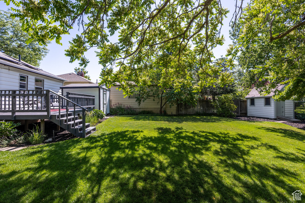 View of yard with a storage shed and a deck
