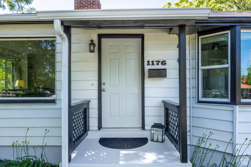 Entrance to property featuring a chimney and covered porch