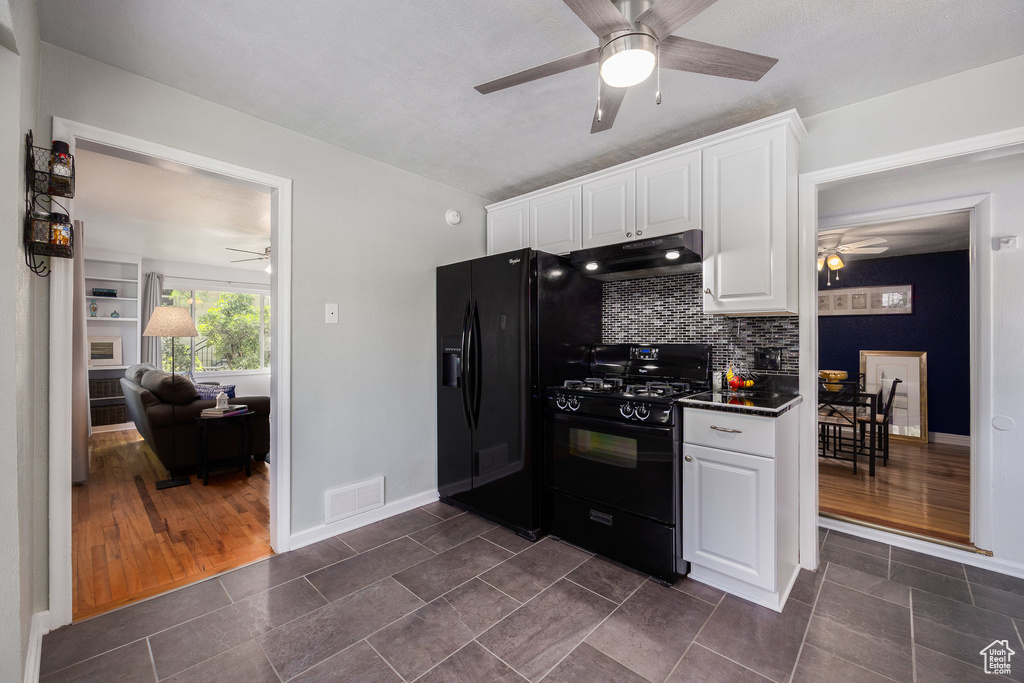 Kitchen with black appliances, a ceiling fan, under cabinet range hood, and white cabinets