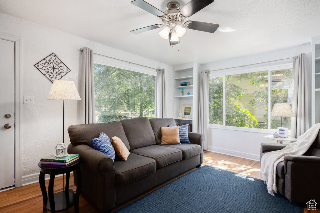 Living area with wood finished floors and ceiling fan