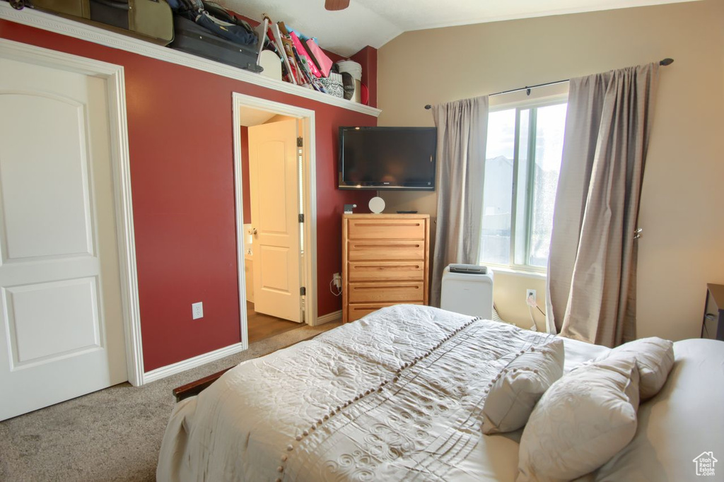 Bedroom with vaulted ceiling and carpet