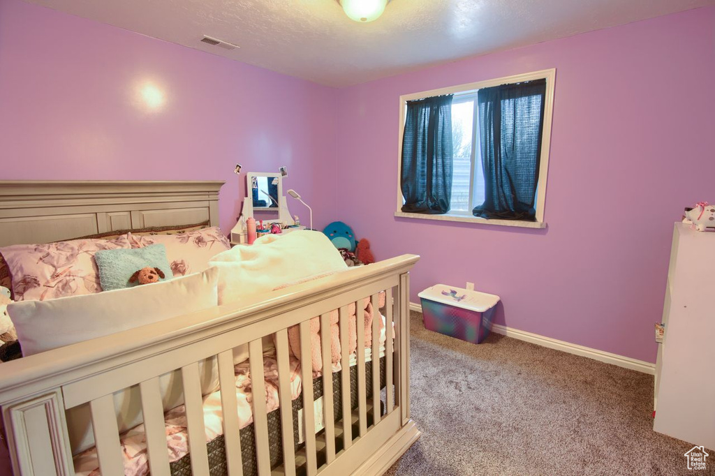 Carpeted bedroom with baseboards and a textured ceiling
