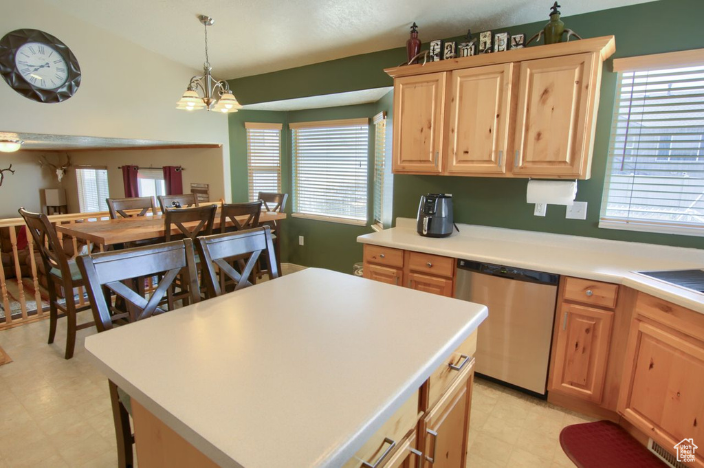 Kitchen with stainless steel dishwasher, light brown cabinets, light floors, and a chandelier