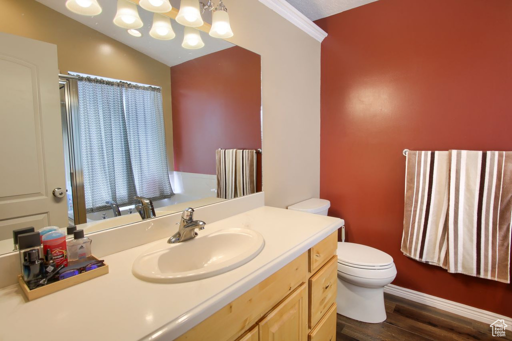 Bathroom with wood finished floors, vanity, and a chandelier