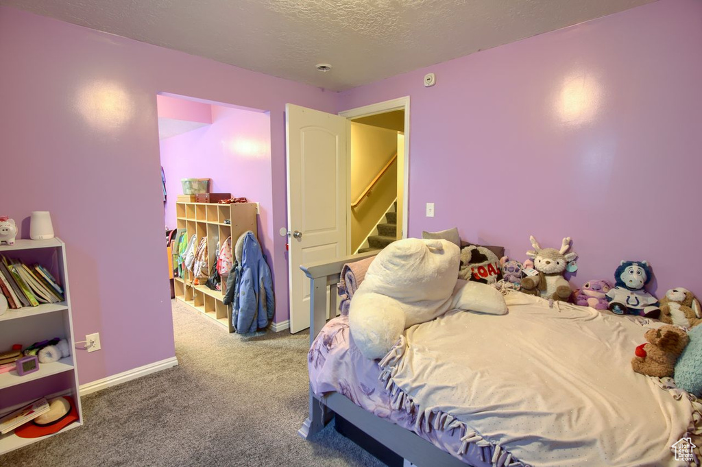 Bedroom featuring carpet flooring and a textured ceiling