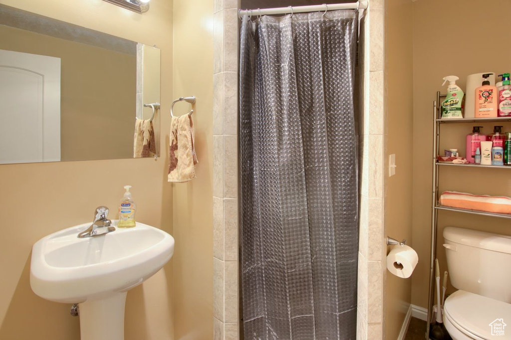 Full bath featuring toilet and a shower with curtain