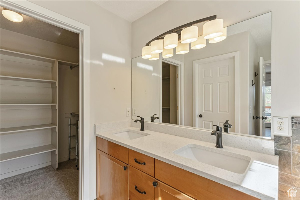 Full bath with double vanity and a walk in closet