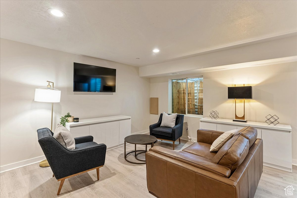 Living room featuring light wood-type flooring, baseboards, and recessed lighting