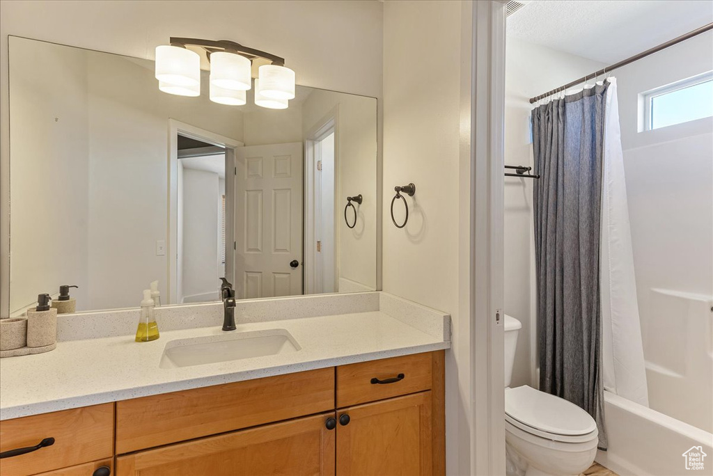 Full bath with vanity, toilet, and shower / bath combination with curtain