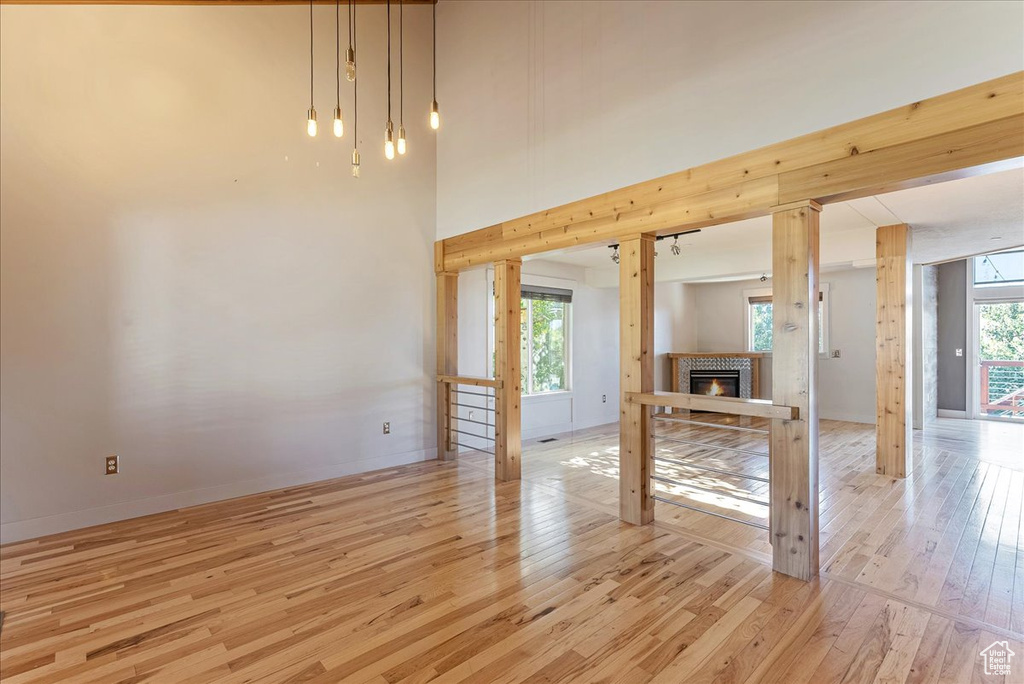 Unfurnished living room featuring light wood-type flooring and a glass covered fireplace