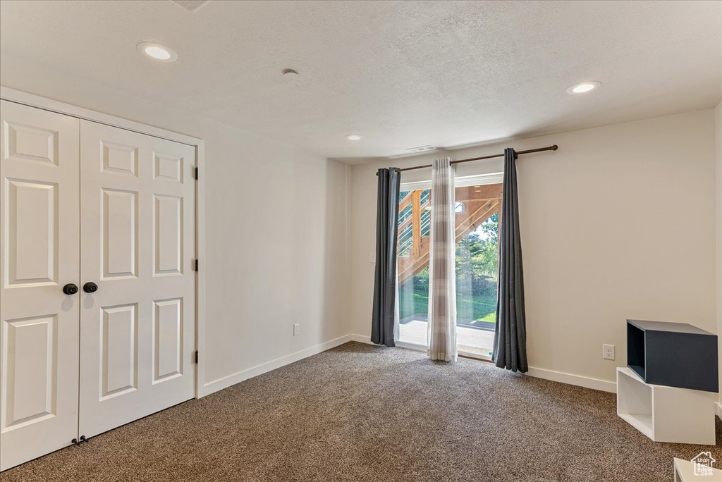 Unfurnished bedroom with carpet flooring, baseboards, recessed lighting, access to exterior, and a textured ceiling