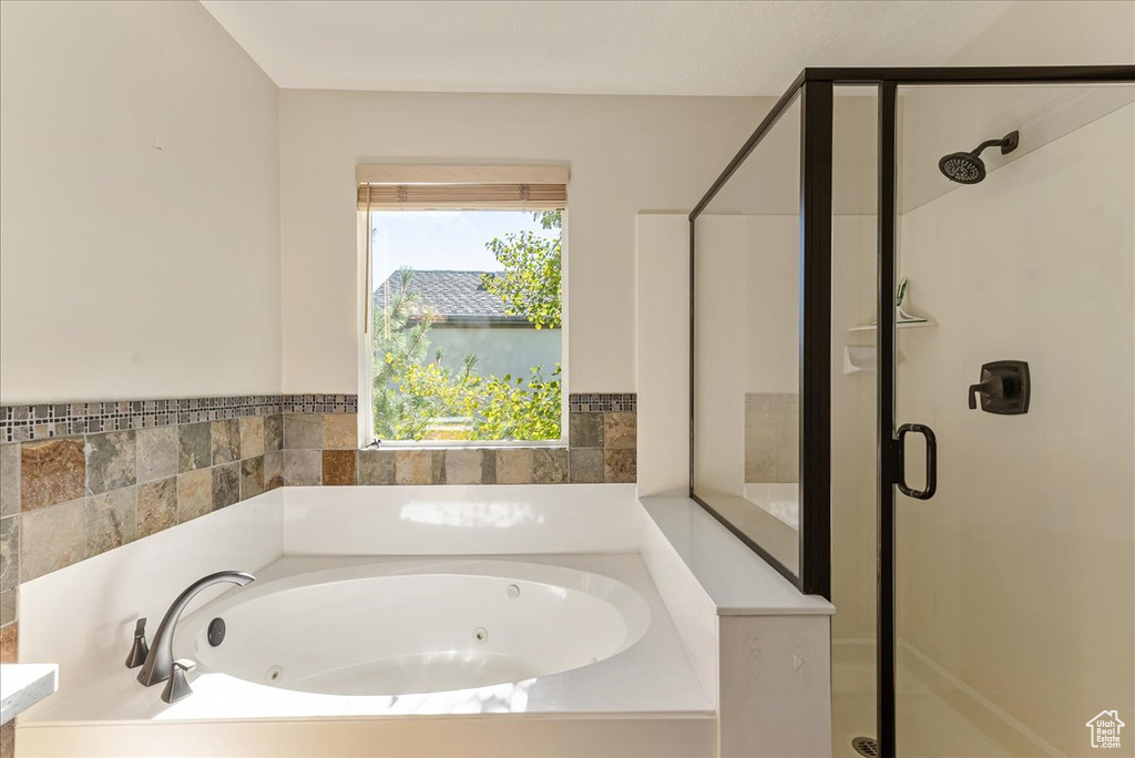 Bathroom featuring a shower stall and a jetted tub