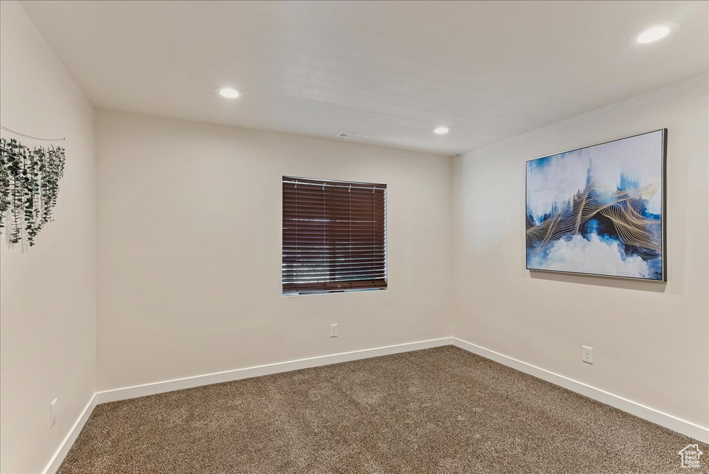 Carpeted empty room featuring recessed lighting and baseboards