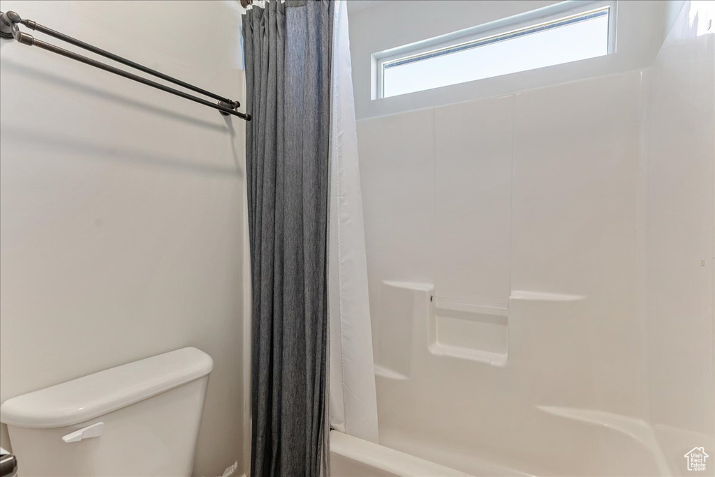 Full bath with toilet and shower / bathtub combination with curtain