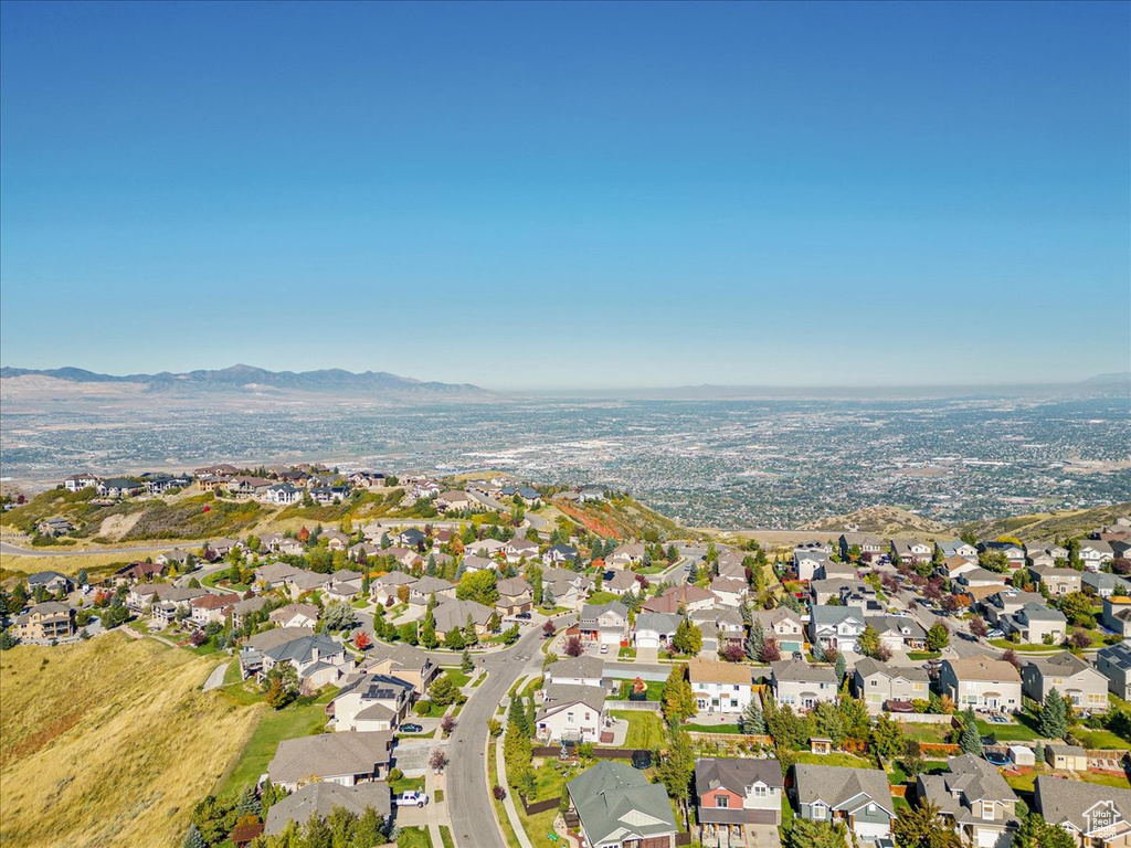 Aerial view of property and surrounding area featuring nearby suburban area and mountains