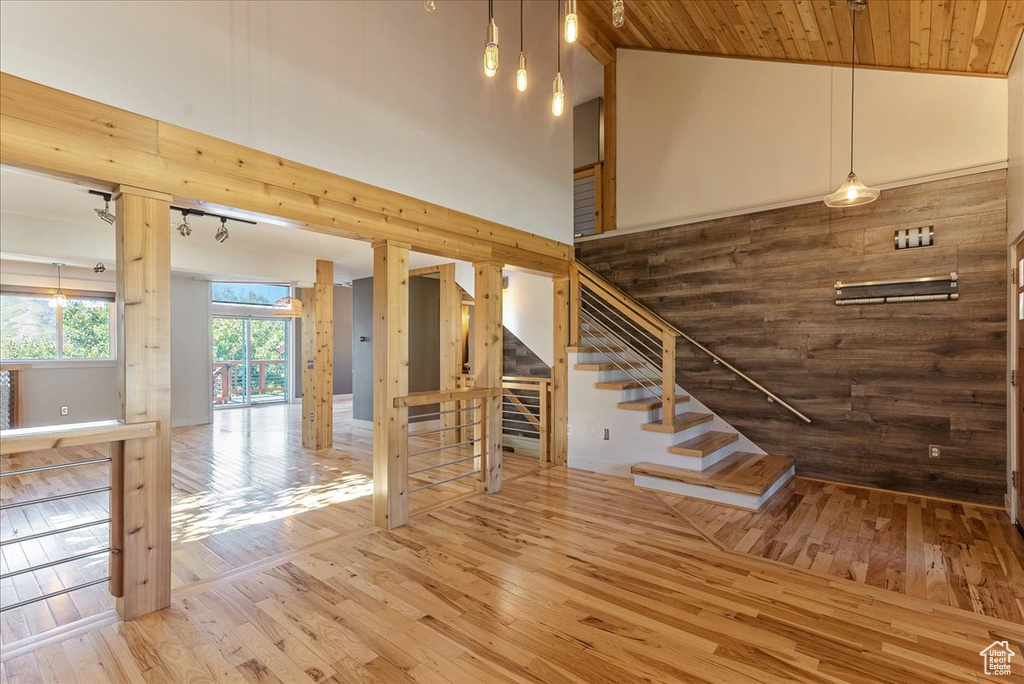 Stairway with hardwood / wood-style floors, high vaulted ceiling, and wood ceiling