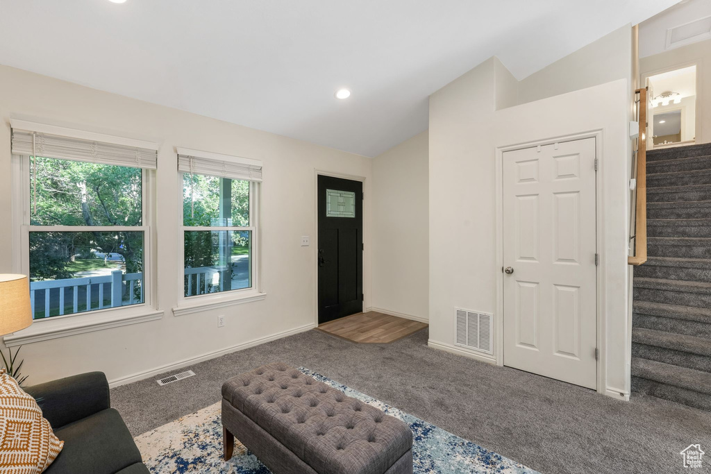 Carpeted living area with lofted ceiling, stairway, and recessed lighting