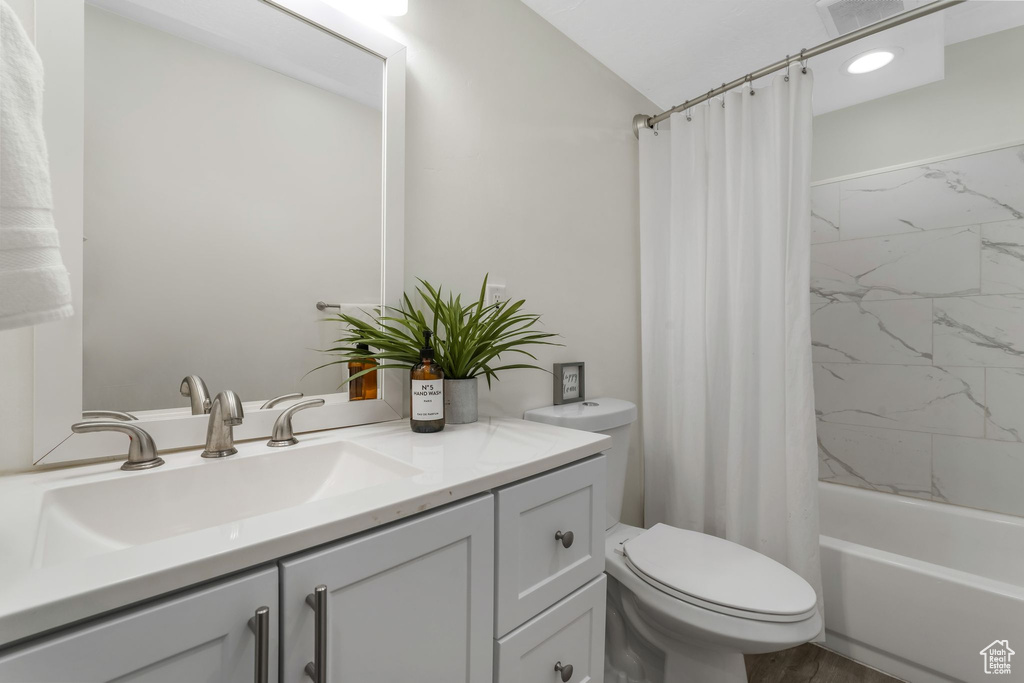 Full bath featuring vanity and shower / bath combination with curtain