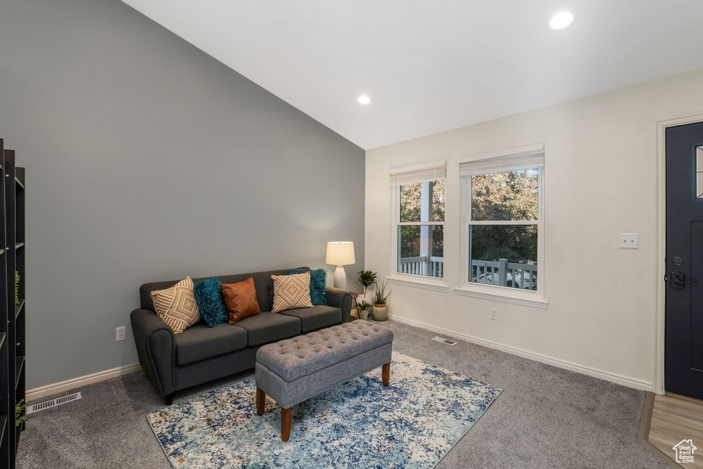 Carpeted living area featuring vaulted ceiling and recessed lighting