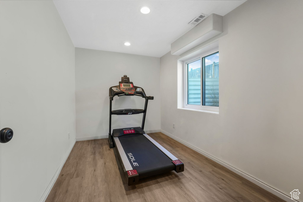 Exercise area featuring wood finished floors and recessed lighting