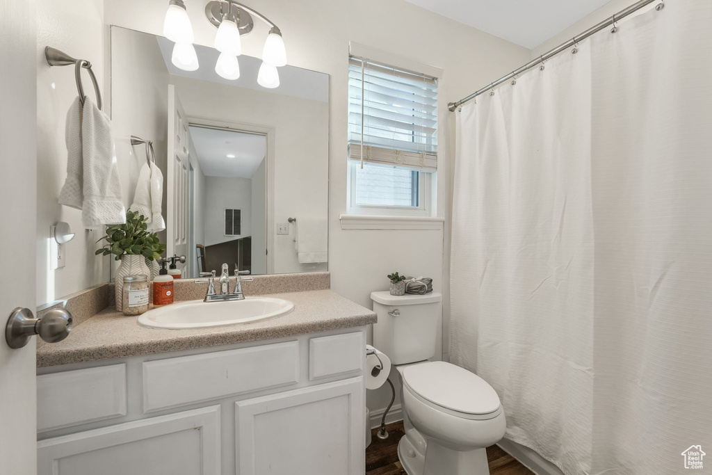 Full bath with vanity, wood finished floors, and a shower with curtain