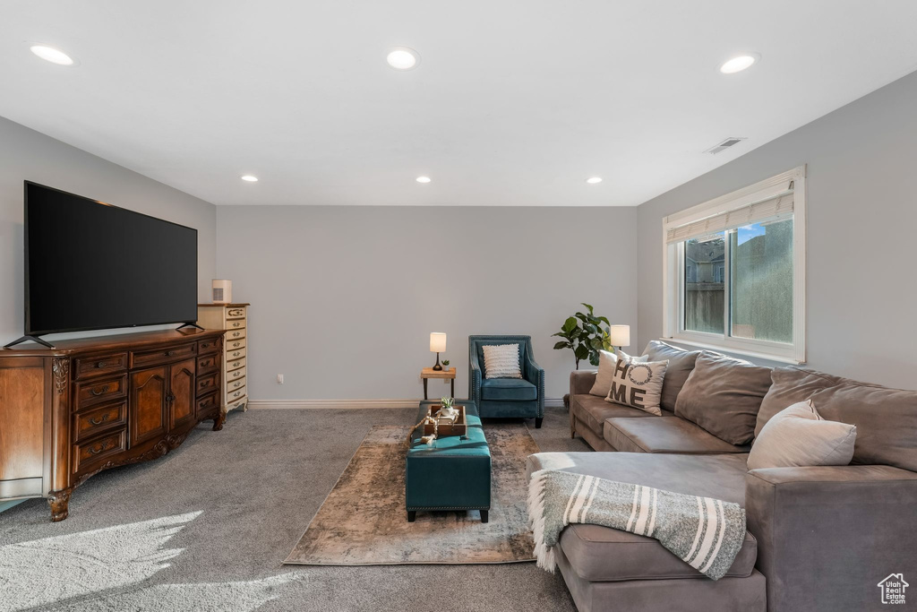 Carpeted living area featuring recessed lighting and baseboards