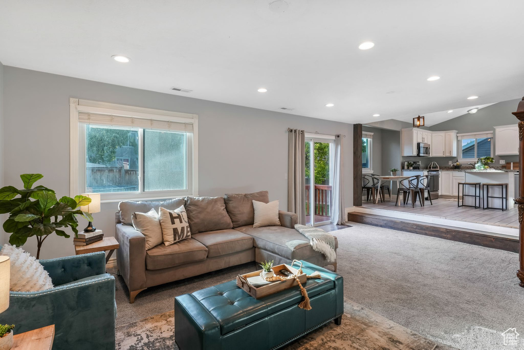 Living room with recessed lighting, light carpet, and lofted ceiling