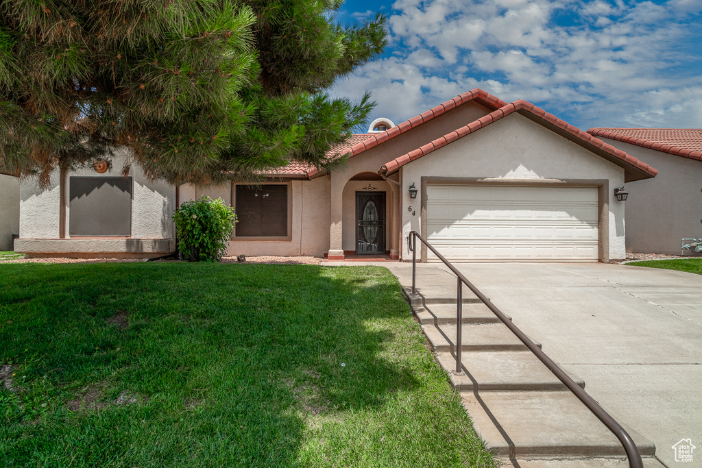Mediterranean / spanish-style house featuring concrete driveway, a garage, stucco siding, a front yard, and a tile roof