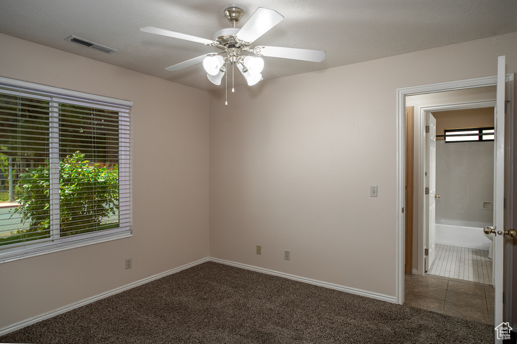 Empty room with carpet flooring, a ceiling fan, and baseboards