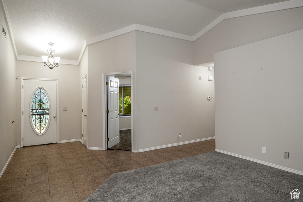 Foyer entrance featuring a chandelier, healthy amount of natural light, lofted ceiling, and baseboards