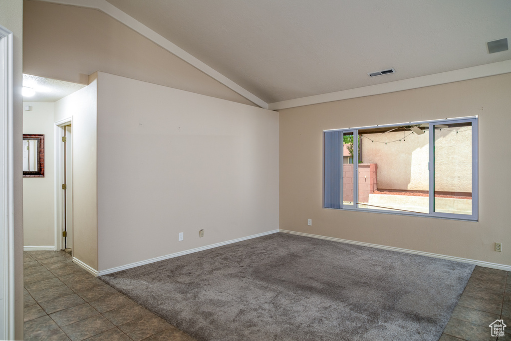 Unfurnished room featuring vaulted ceiling, baseboards, and carpet flooring