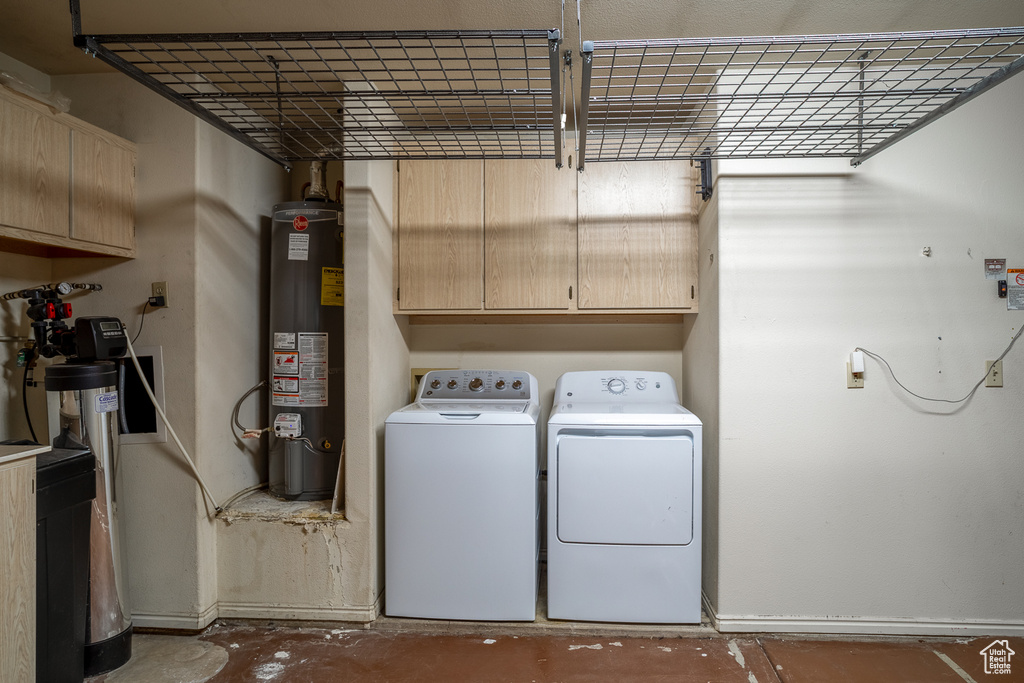 Laundry room with water heater, washer and dryer, and cabinet space